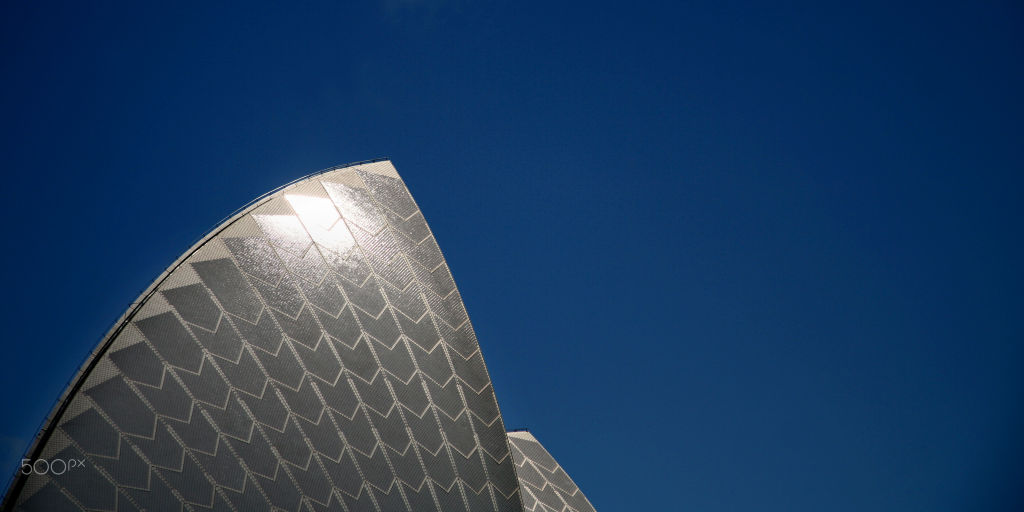 Close-up of a Sydney Opera House shell against a deep blue sky