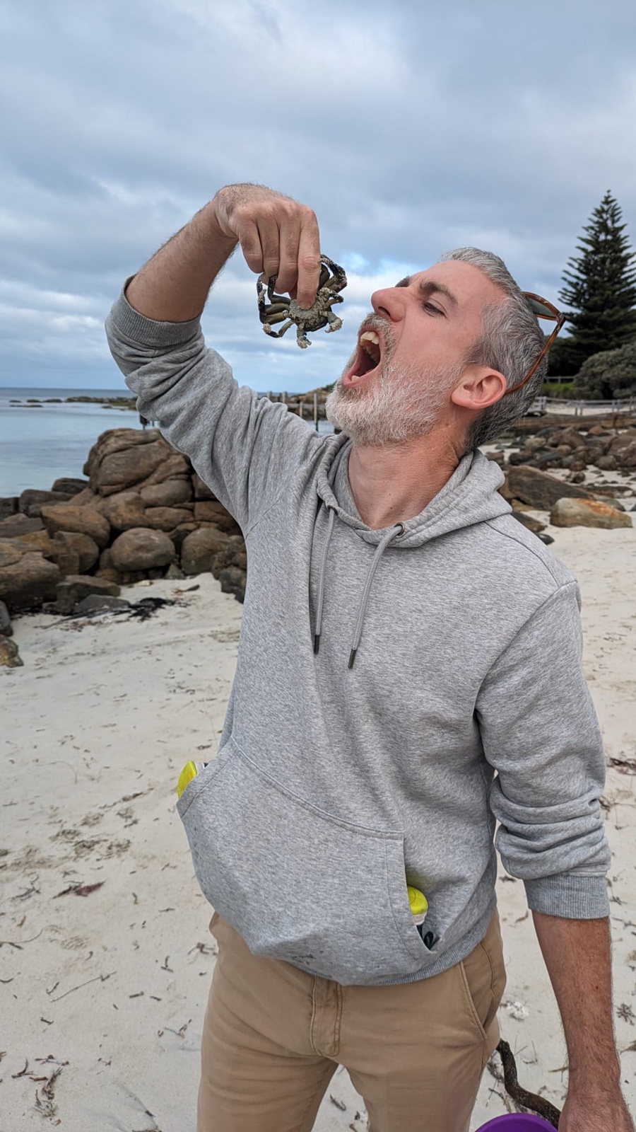 Pierre on a beach pretending to eat a small crab